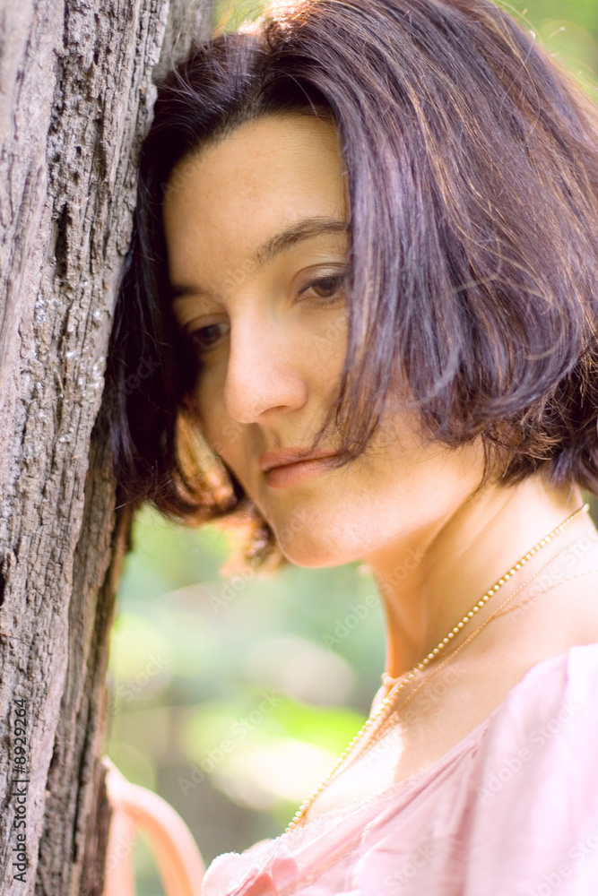 portrait of unhappy woman near old tree portrait of unhappy woman near old tree