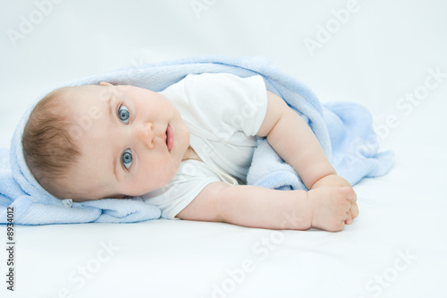 little, cute baby boy lying on white background