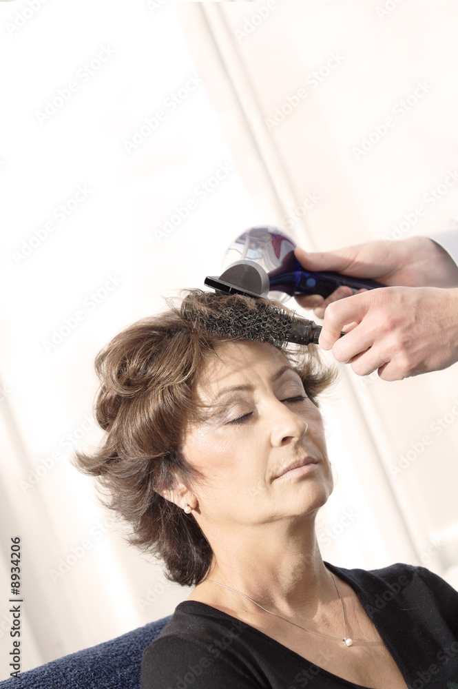 Naklejka premium Senior woman having haircut in barber shop.