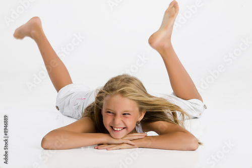 Fotografie The blonde teen-age girl plays, jumps and laughs