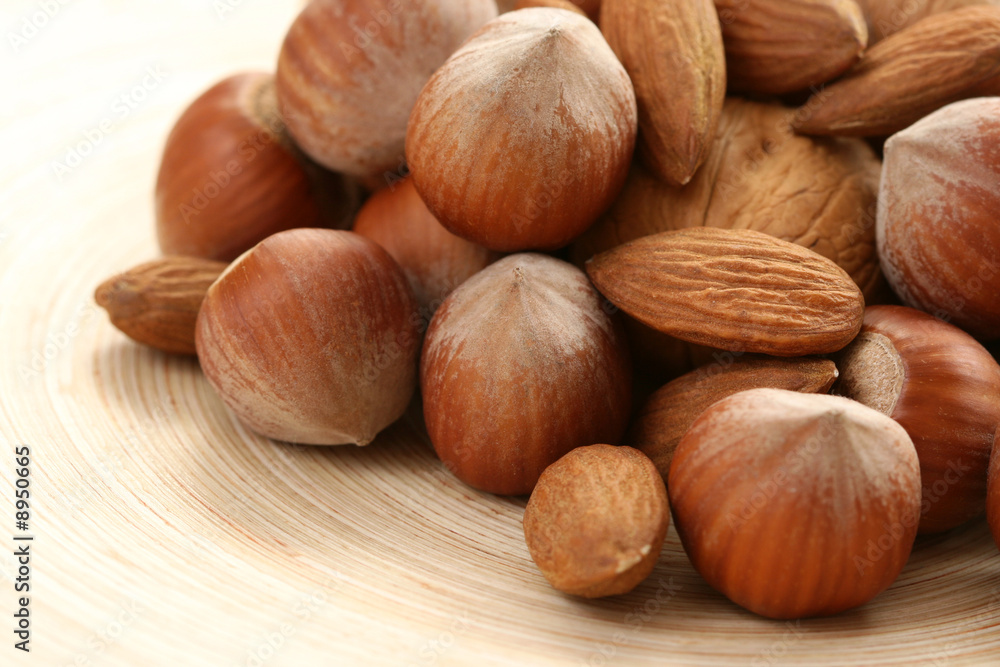 close-ups of hazelnuts and walnuts on wooden table close-ups of hazelnuts and walnuts on wooden table