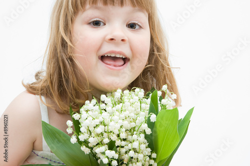 little, pretty girl holding bunch of lilies of the valley