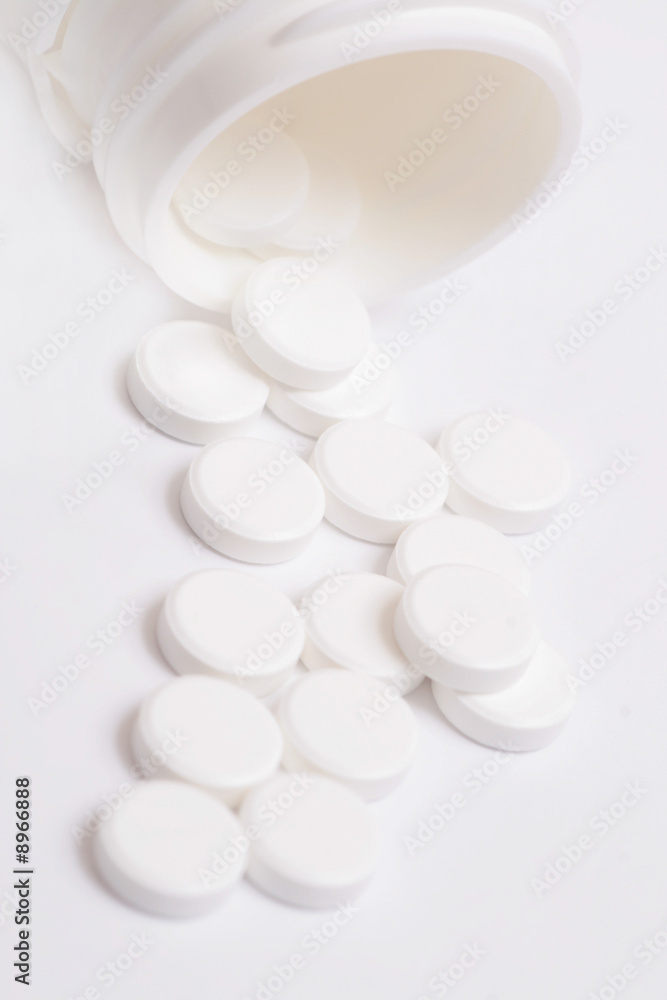 White pills spilling out of pill bottle. White pills spilling out of pill bottle.