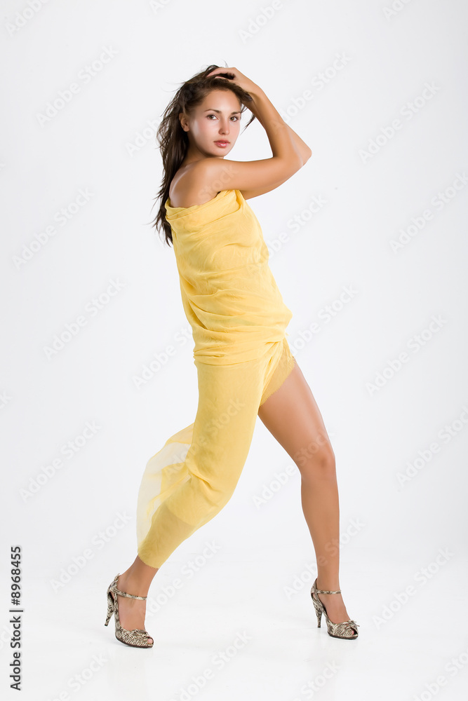 Young brunete woman in a piece of yellow fabric