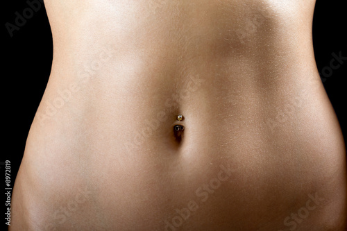 a sexy tummy of the young woman. Isolated on black