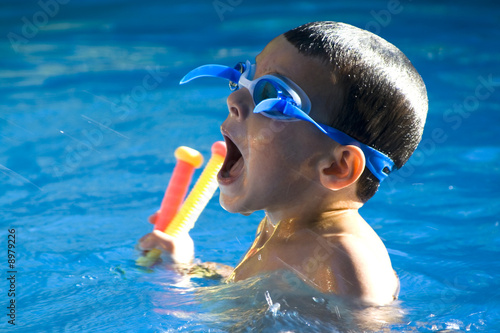 Little boy in the swimming pool trying to get water in his mouth