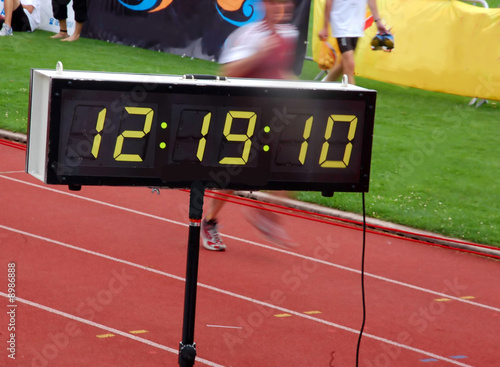 Finishing runner during a triathlon with stopwatch