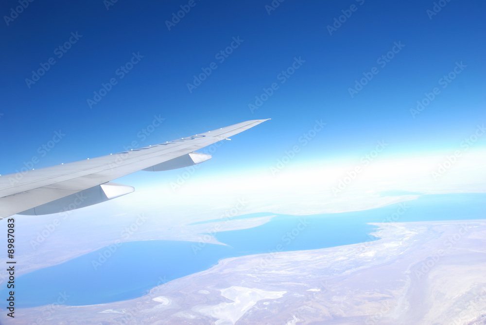 Fototapeta premium Plane wing against blue sky