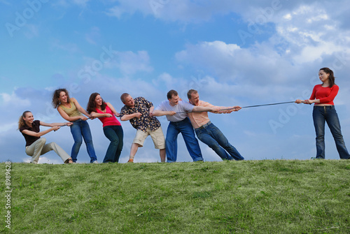 Foto Group of happy people pulling the rope