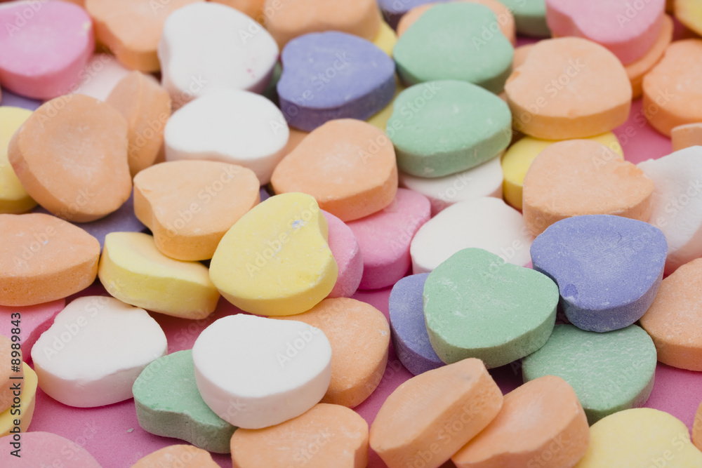 Multi color candy hearts on a pink background Multi color candy hearts on a pink background