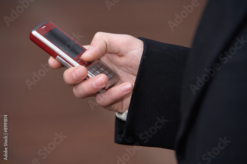 Teenage boy holding mobile phone in hand, exterior