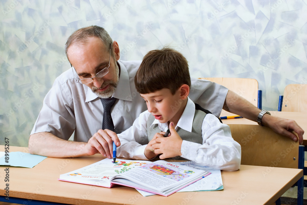 Teacher and schoolboy read alphabet. Primary school. Teacher and schoolboy read alphabet. Primary school.
