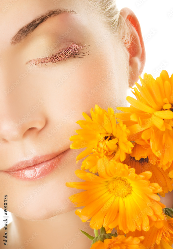 Beautiful young woman's face with orange flowers Beautiful young woman's face with orange flowers