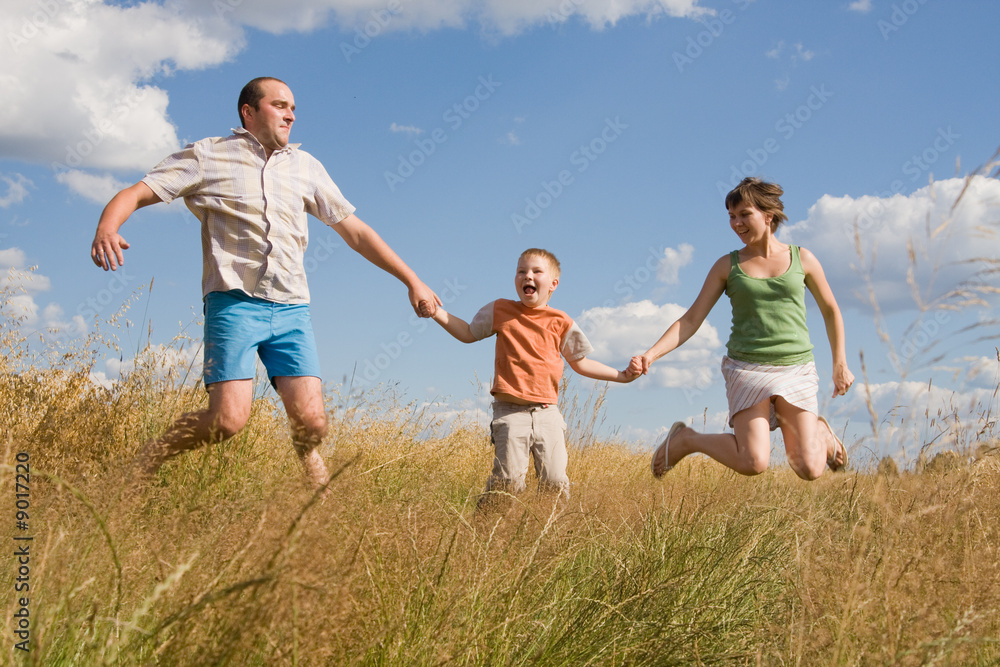 happy family jumping together on a summer day happy family jumping together on a summer day