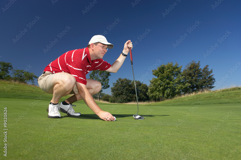 Obraz premium caucasian golfplayer concentrating before putting on golfcourt