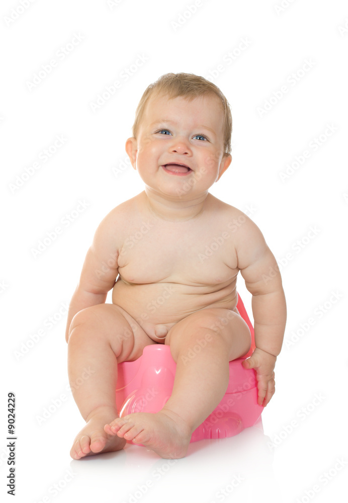 Small smiling baby on pink chamber-pot isolated Small smiling baby on pink chamber-pot isolated