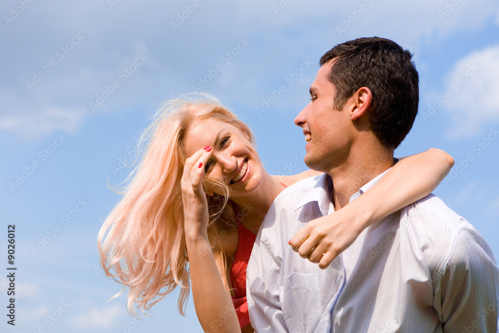 Young love Couple smiling under blue sky Young love Couple smiling under blue sky