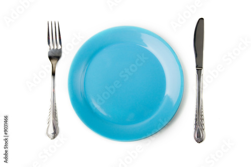 a set of metal fork and knife and blue plate