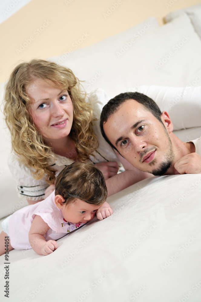 indoor portrait with happy young family and  cute little babby