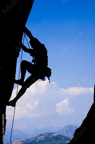 Rock climber clinging to a cliff.