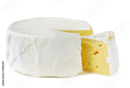A wheel of rich creamy brie cheese, with a wedge cut out.