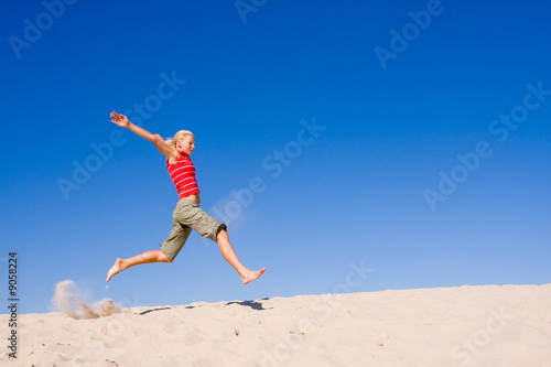 beautiful female exercising on the sand dunes