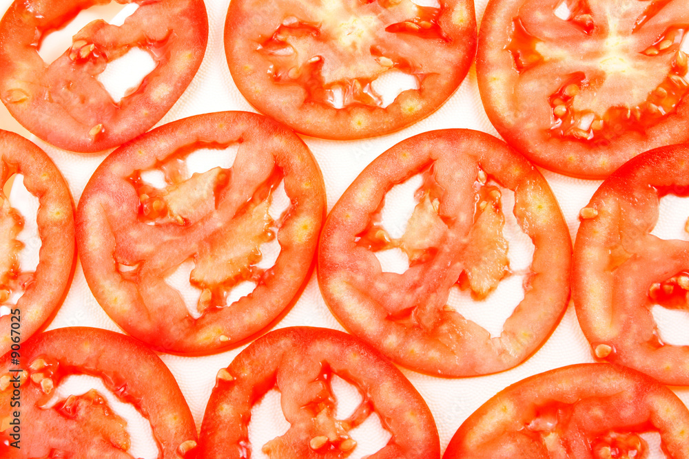 Background from thin slices a tomato of red color.
