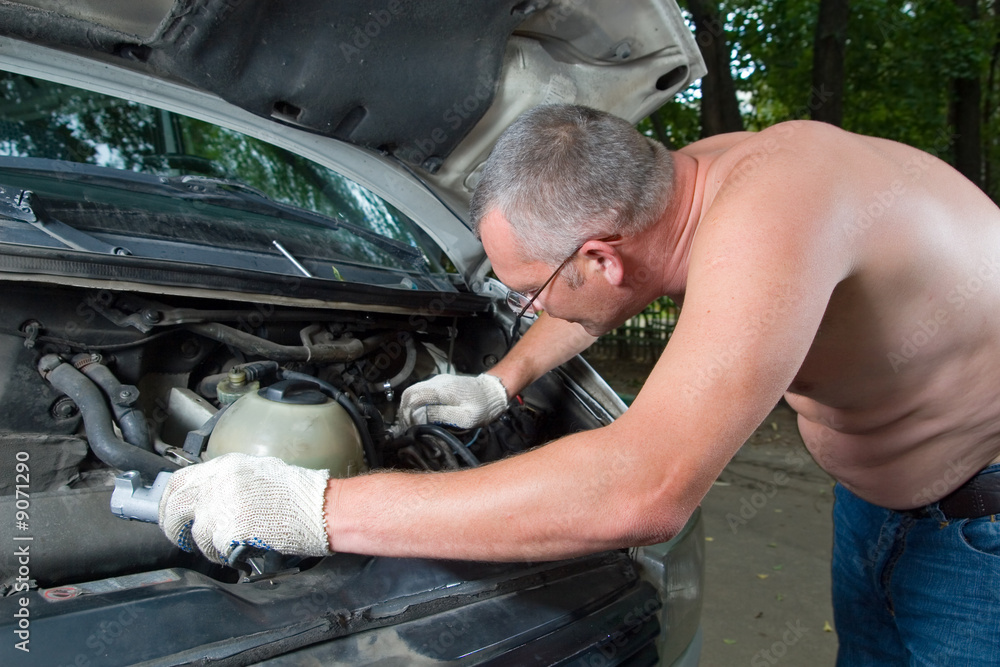 Man mechanic repairing his car on the road Man mechanic repairing his car on the road