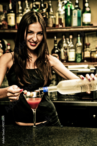 A young female bartender, photographed at work.