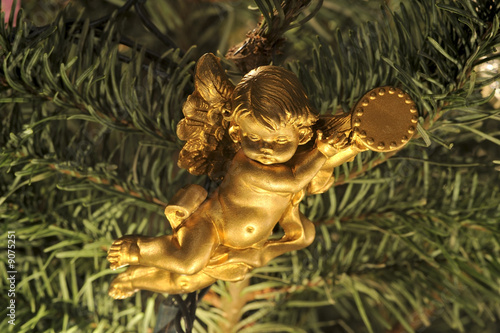 Hanging angel  cherub  ornament in a Christmas tree. Macro.