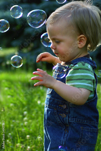 Little boy in a field playing with bubbles