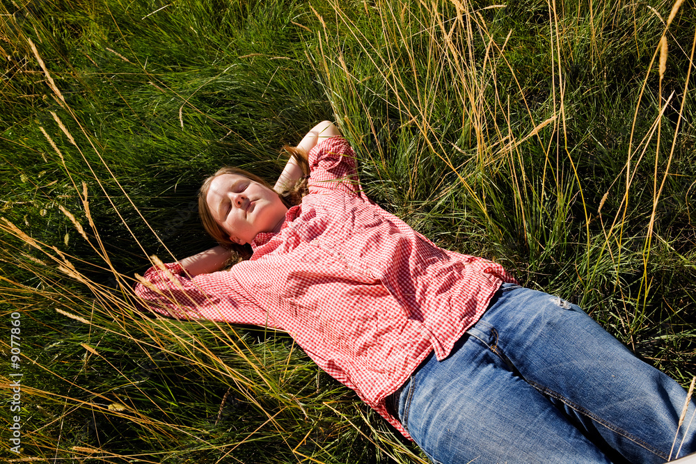 A country farm girl relaxing in the grass A country farm girl relaxing in the grass