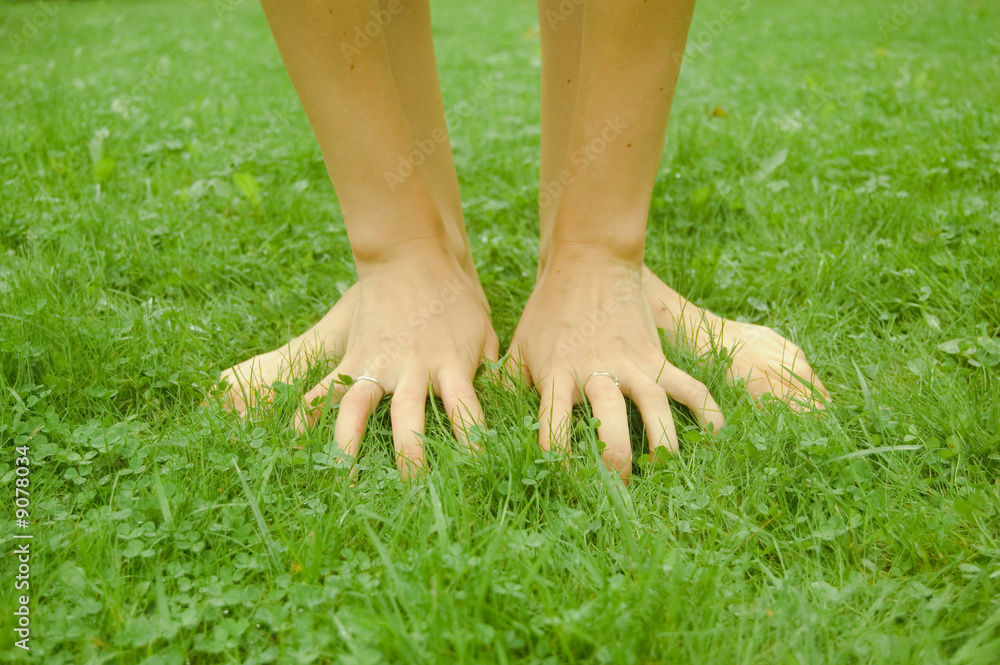 hands and feet on grass background