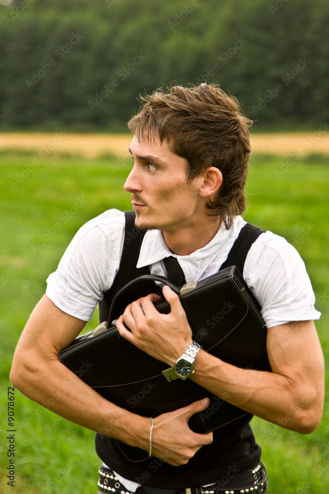 Fototapeta premium Treasure concept - young man holding this bag and looking round