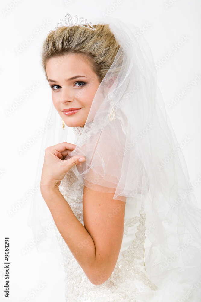 Portrait of pretty bride wearing veil and touching it Portrait of pretty bride wearing veil and touching it