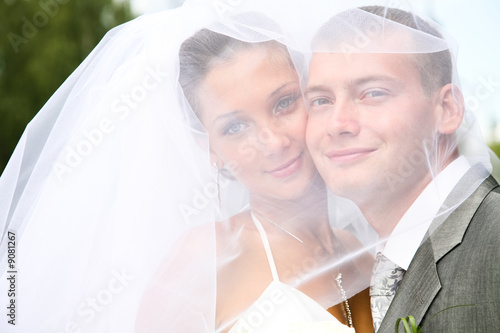 Portrait of happy bride and groom touching each other