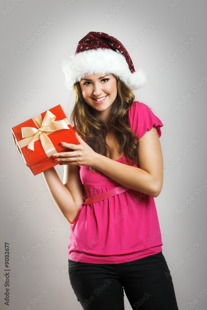 smiling woman with a christmas hat and a red gift smiling woman with a christmas hat and a red gift