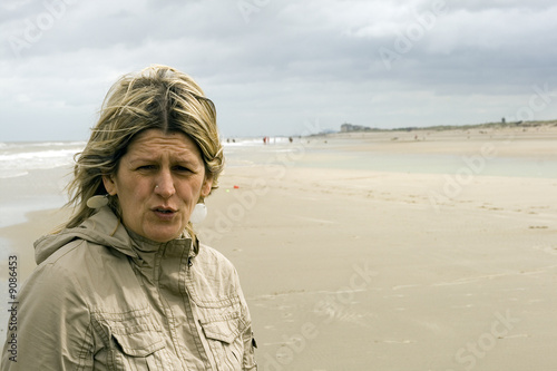 femme au vent sur la plage,ciel gris