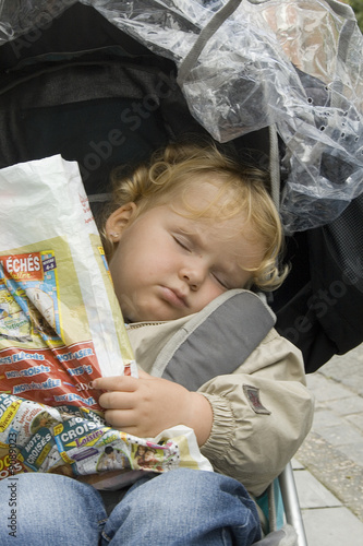 Bébé dormant dans un poussette un sac à la main