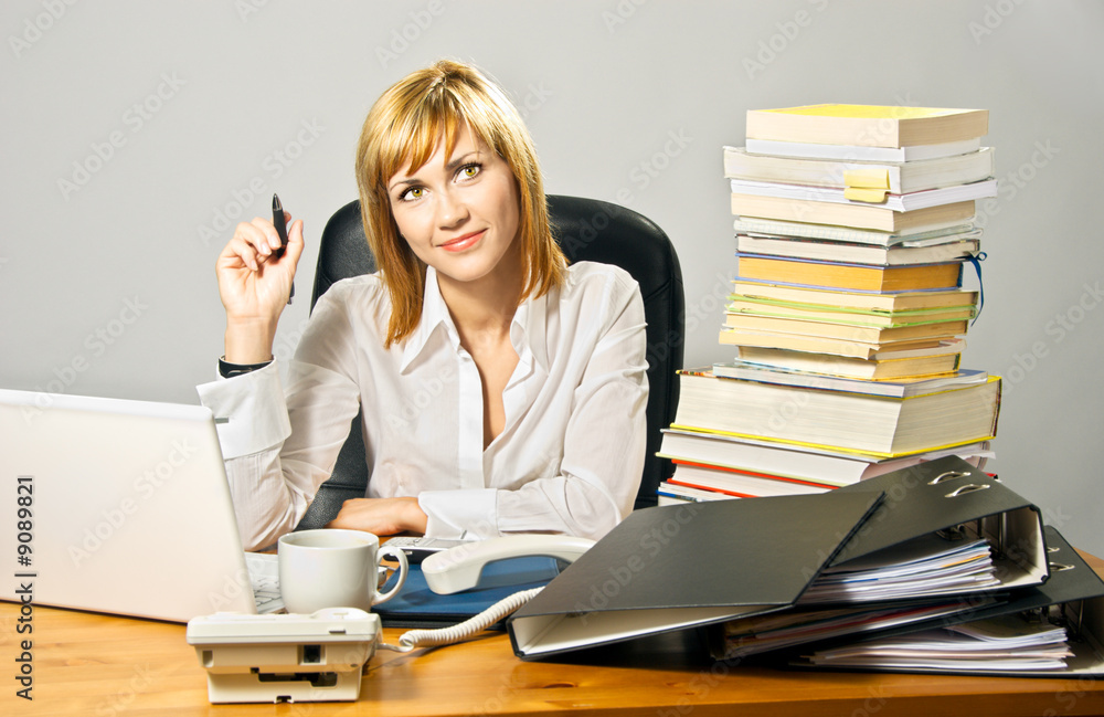 Young beautiful business lady working at a busy desk. Young beautiful business lady working at a busy desk.