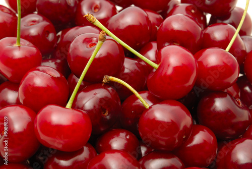 Background from a red cherry with green fruit steams