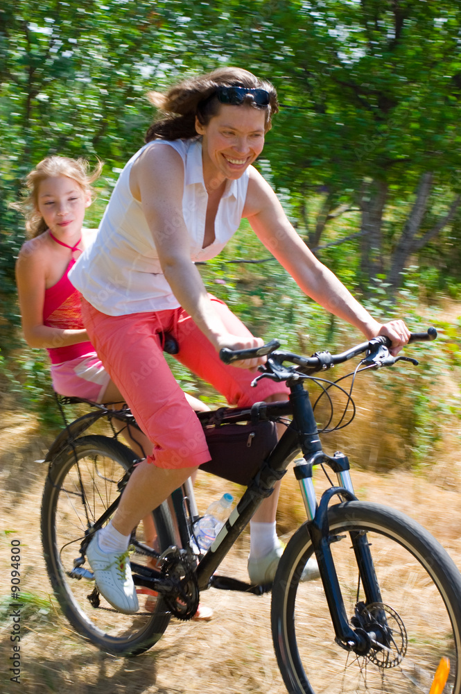 Fototapeta premium mother and daughter on bike