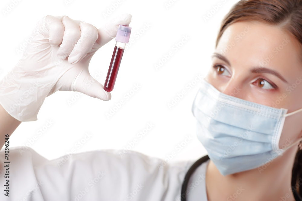 A young female health professional looking at a blood sample
