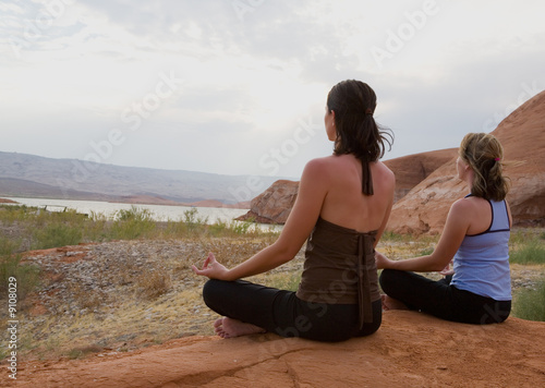 Yoga at sunset and two women
