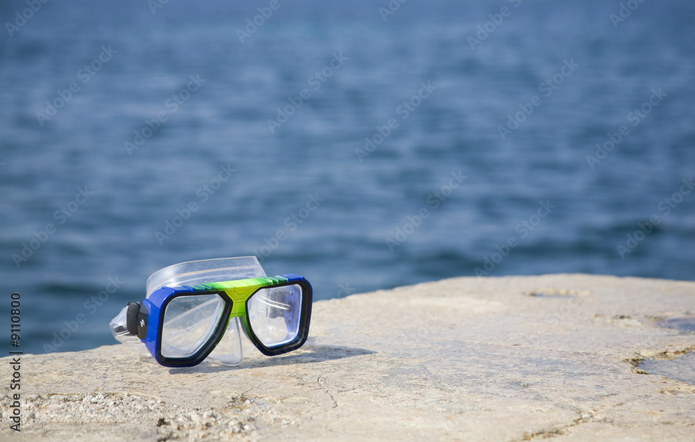 A goggles on a ronck close to the sea