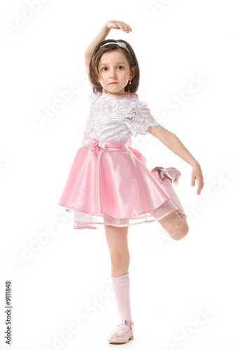 The lovely little girl posing in a beautiful pink dress.