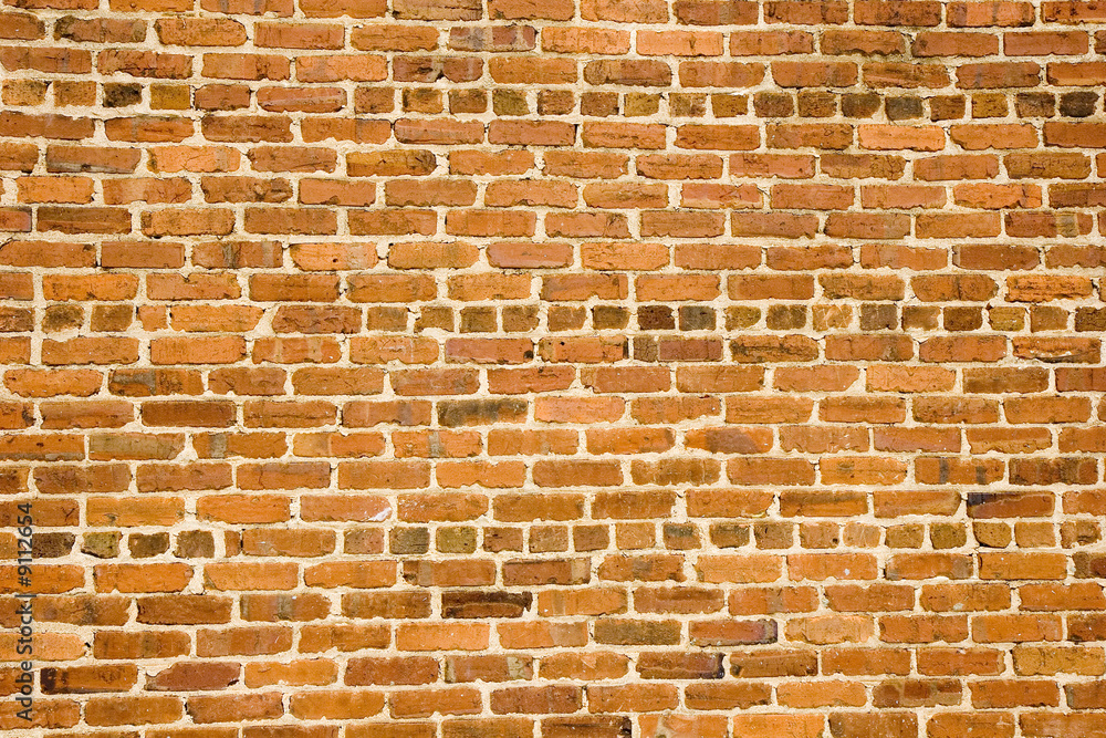 Fototapeta premium An old brick wall of orange and red bricks