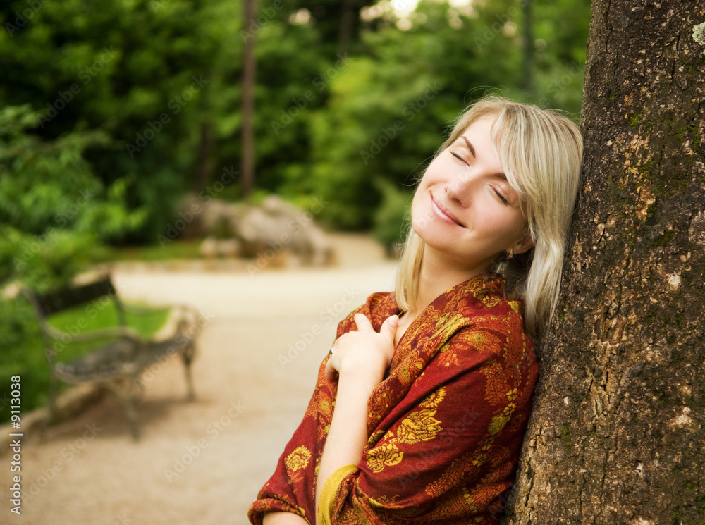 Naklejka premium Beautiful young woman relaxing in a park