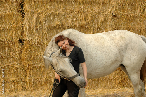 Woman and horse on a background  of straw.