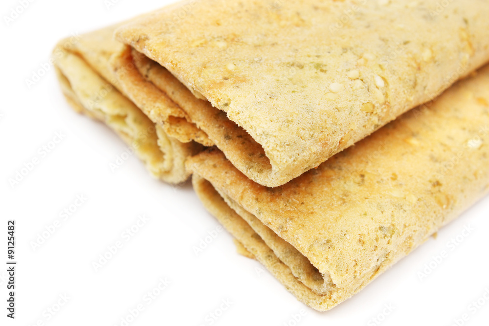 Three eggroll biscuits stacked together on white background.